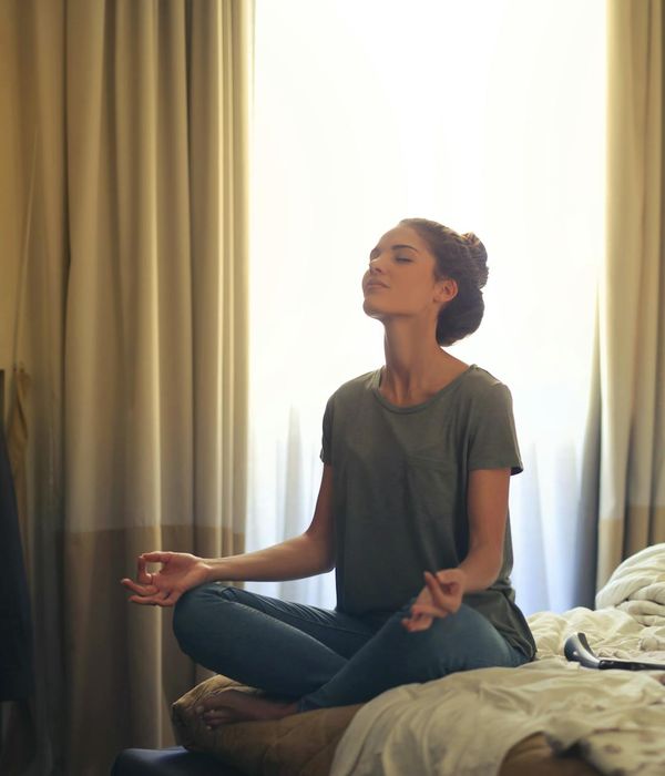 Calm person sitting in a relaxed posture by a window.